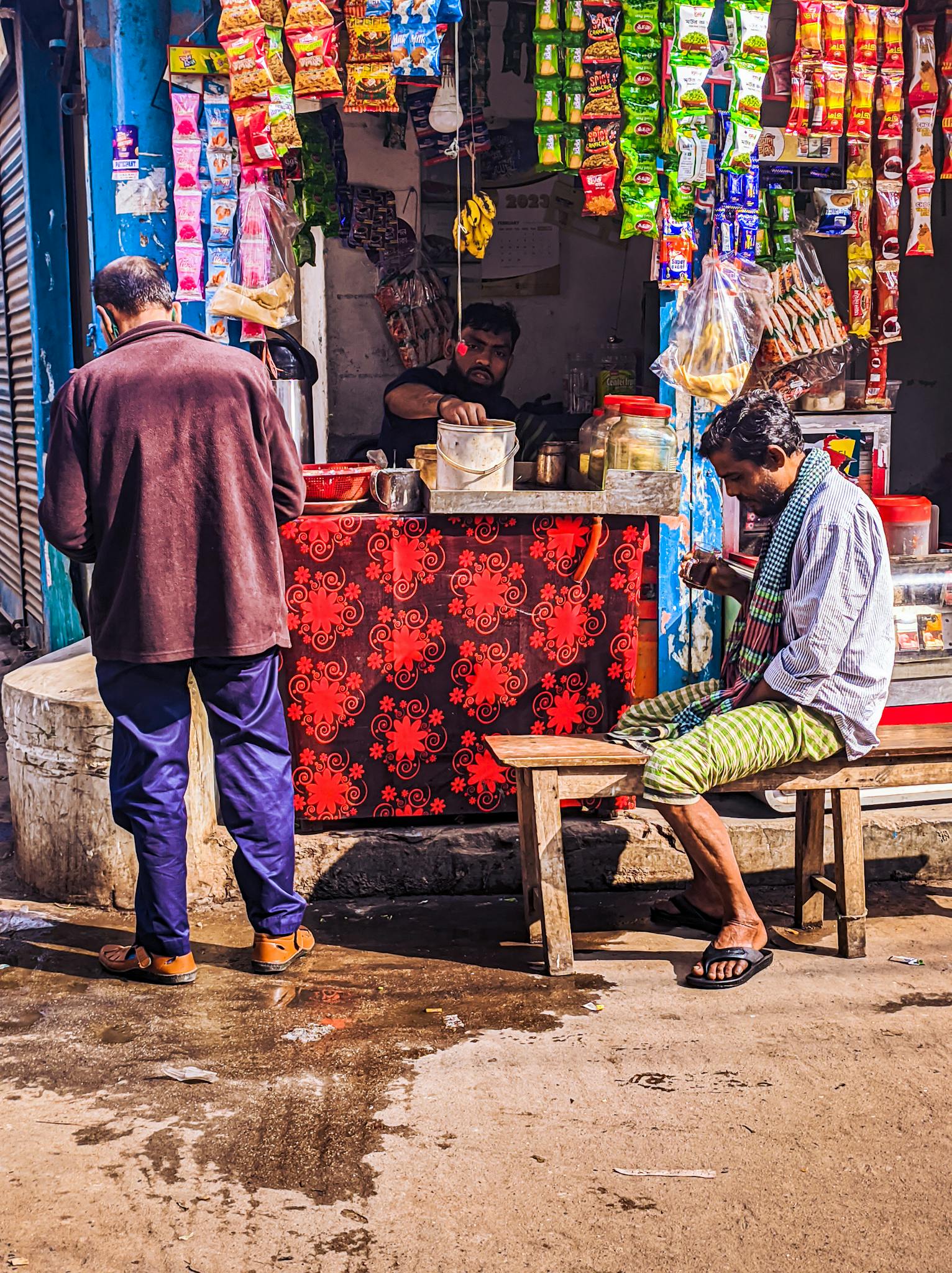 Colorful urban scene of men interacting at a street market in Dhaka, Bangladesh.